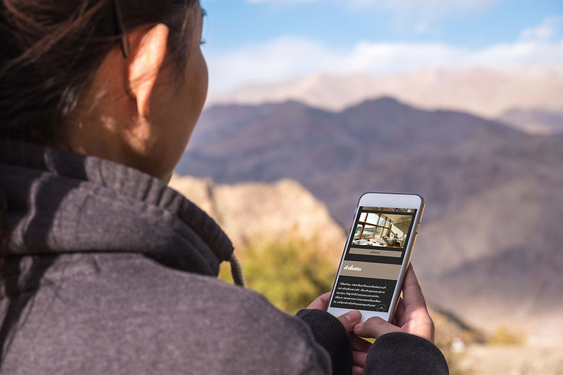 ผู้หญิงอยู่บนภูเขามองที่หน้าจอโทรศํพท์มือถือ