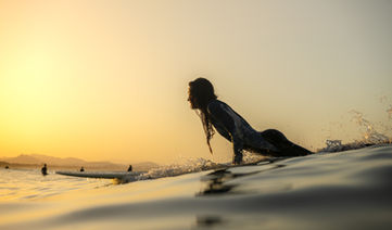 Surfen bij zonsondergang