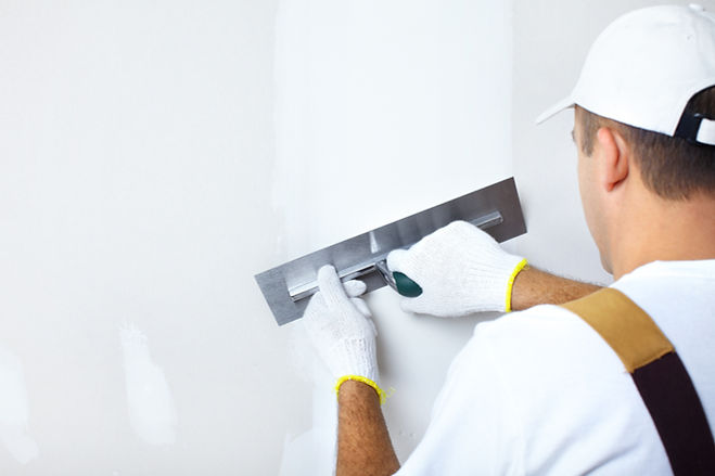 Mature contractor plasterer working indoors