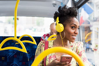 black woman smiling listening to music on phone with headphones