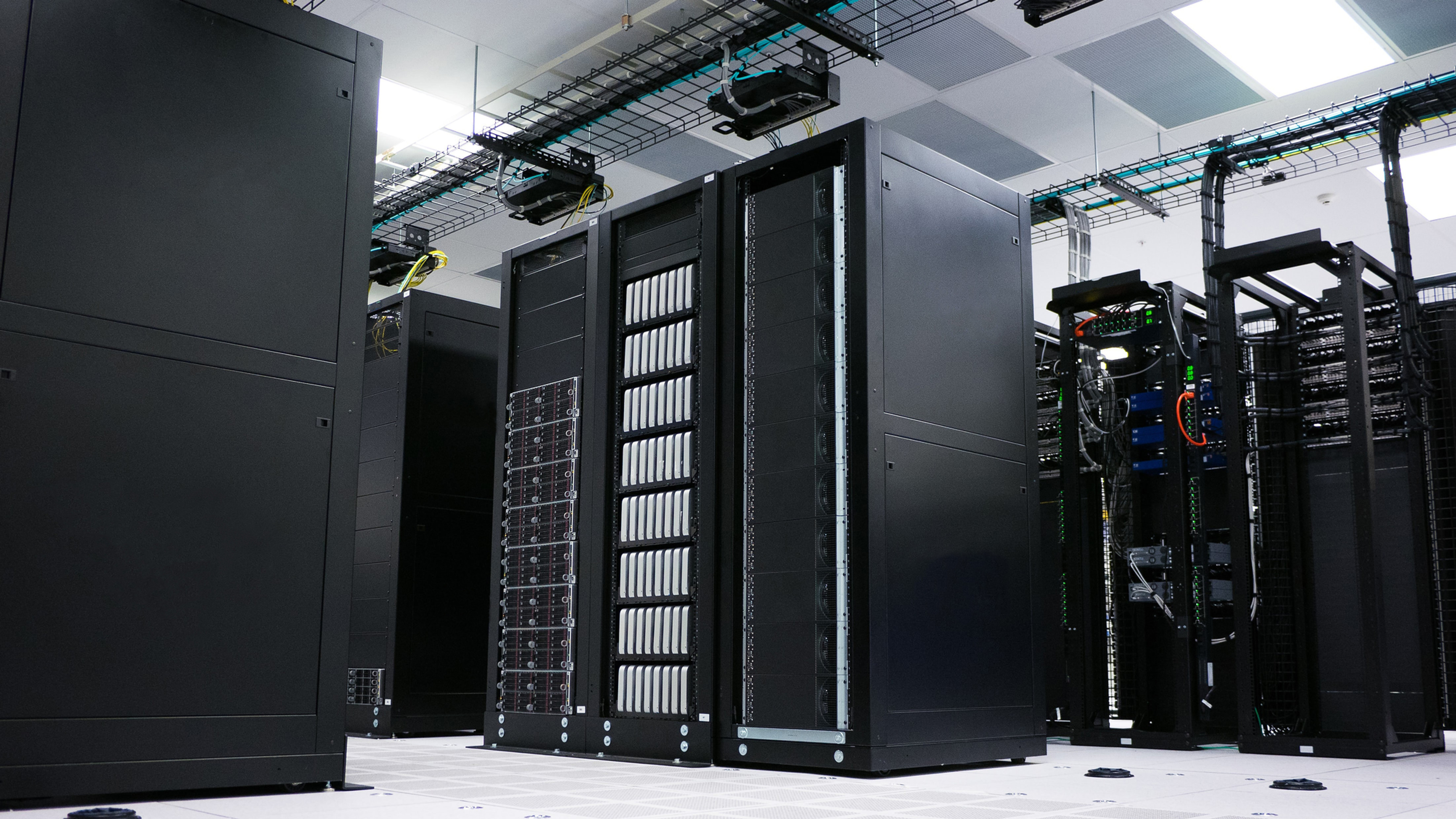 Industrial emergency stop button on a factory control panel next to a data center server rack, representing the AI kill switch challenge