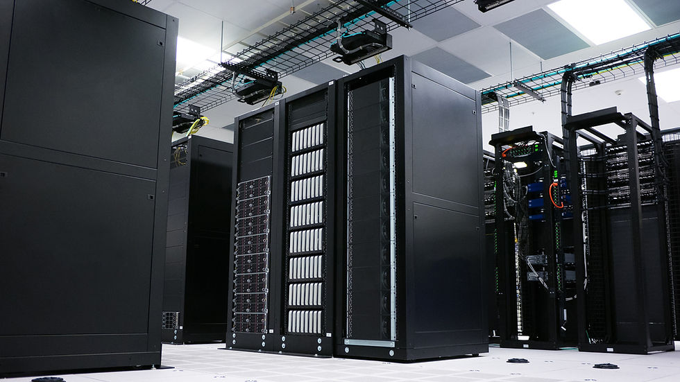Black server racks in a data center, surrounded by cables and ceiling lights. The scene is sterile and orderly, evoking efficiency.