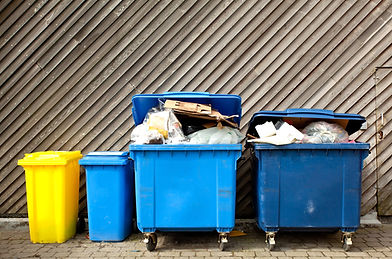 overfilled trash of large wheelie bins for rubbish, recycling and garden waste