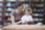 French nanny helping child to read. 