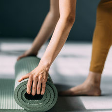Woman unrolling a yoga mat