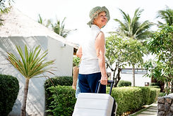 An old lady moving her luggage
