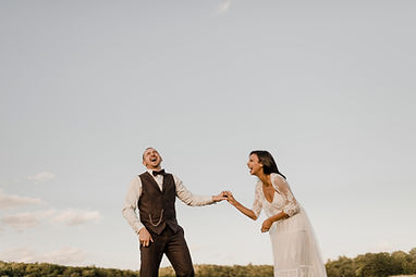 a bride and groom standing together against a stunning sky backdrop radiating love and joy on their special day