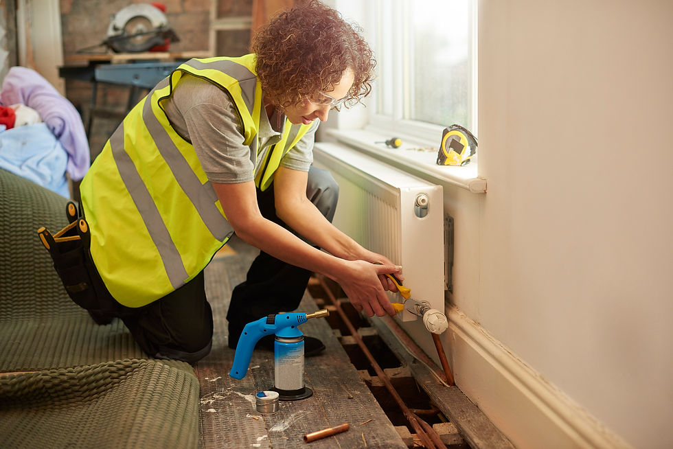 a mid adult female plumber is installing a new radiator into a property