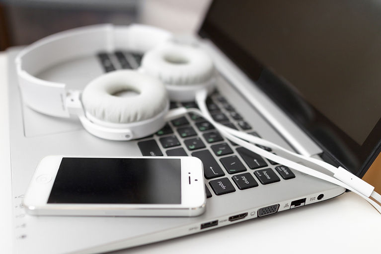 Laptop, fone de ouvido e celular