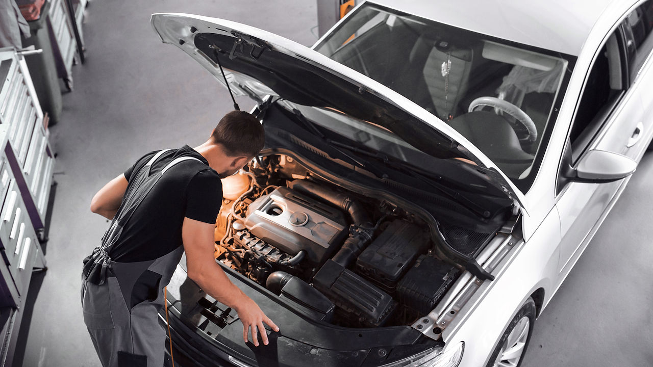 Car mechanic inspecting car in a garage