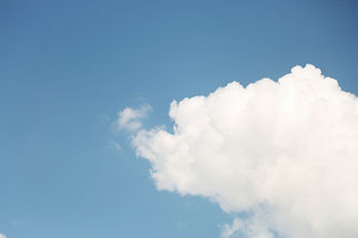 A bright blue sky with a single white cloud drifting into the bottom right corner of the frame, cut off at the edge for a sense of open space and forward motion, representing the straightforward and accessible process of sharing information through Availia TeleHelp PLLC's Release of Information page.