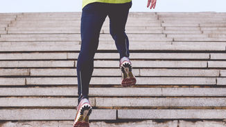 woman sprinting up a hill of steps