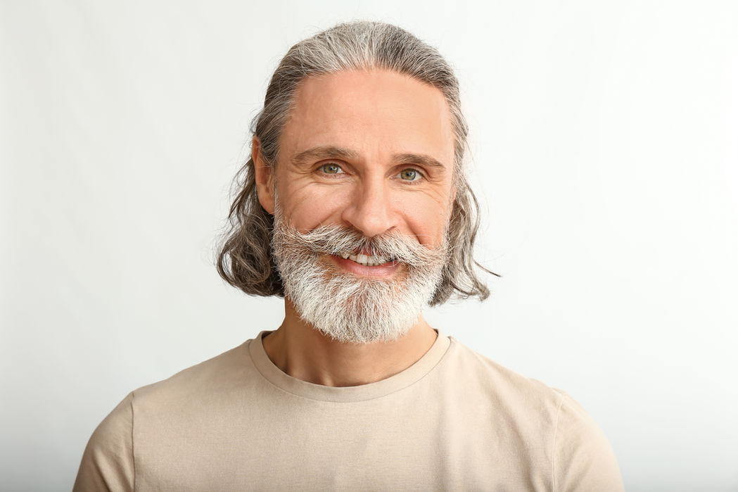 Smiling mature man with gray hair and beard