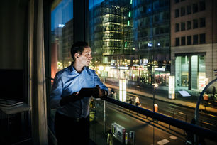 Founder looking out city window at night reflecting on visibility strategy and business growth in 2026