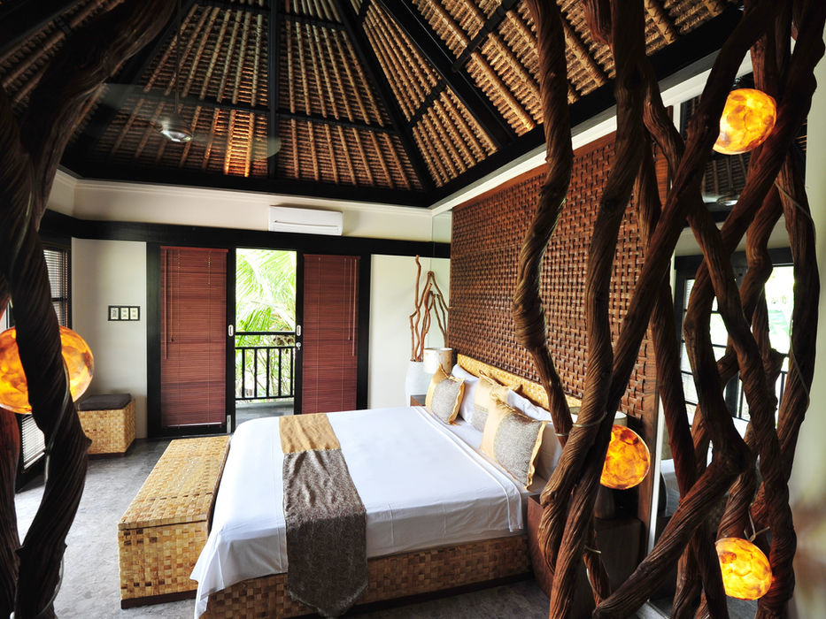 Bedroom with a thatched roof and decorative wooden elements