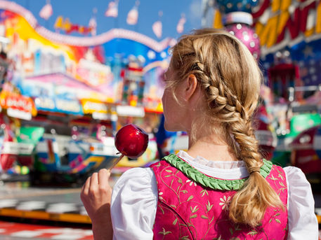 Giovane donna con mela candita all'Oktoberfest di Monaco 