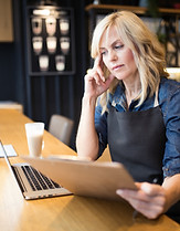 Coffee shop owner working on laptop