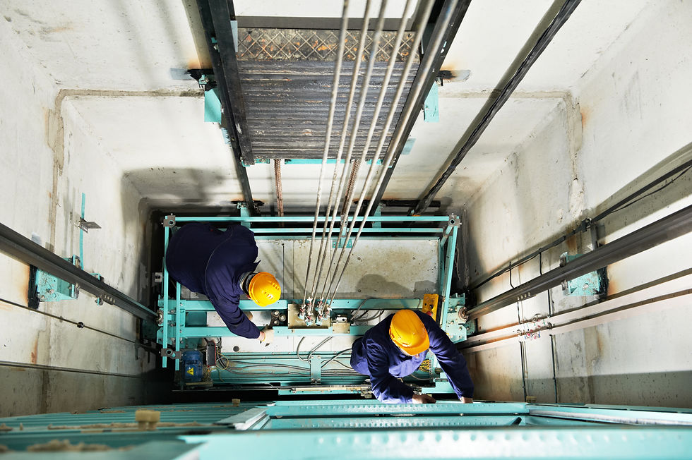 two male technician machinist worker at work adjusting elevator mechanism of lift with spa