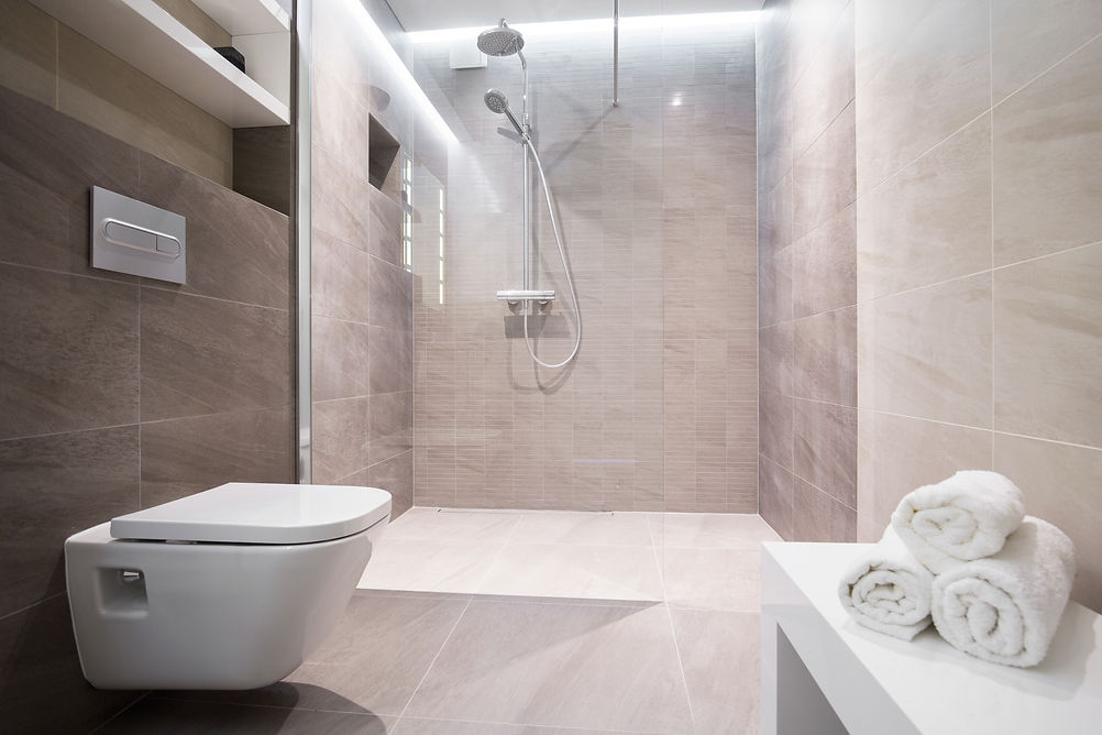 Modern bathroom with sleek beige tiles and a wall-mounted toilet