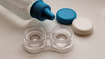 placing disinfectant solution into contact lens cases