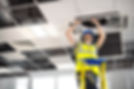 electrician fitting air conditioning to office interior