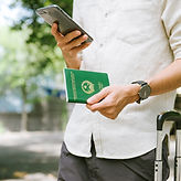 Hombre vietnamita mirando teléfono inteligente mientras tiene un pasaporte