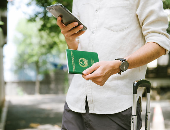 Vietnamese man watching smartphone while holding a passport