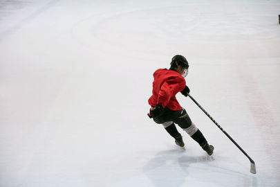 Professional ice hockey athlete in vibrant red jersey demonstrating puck handling mastery, reminiscent of expert portfolio management in a dynamic market.