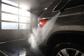 Silver car getting a high-pressure wash