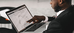 Um homem apontando para a tela do laptop