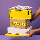 Stacked boxes in front of a purple background showcasing delivery service.
