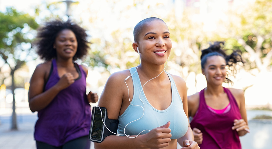 Image of 3 women running together. They look happy and are smiling.