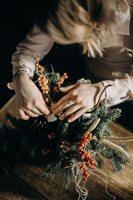 Hands working on Christmas wreath