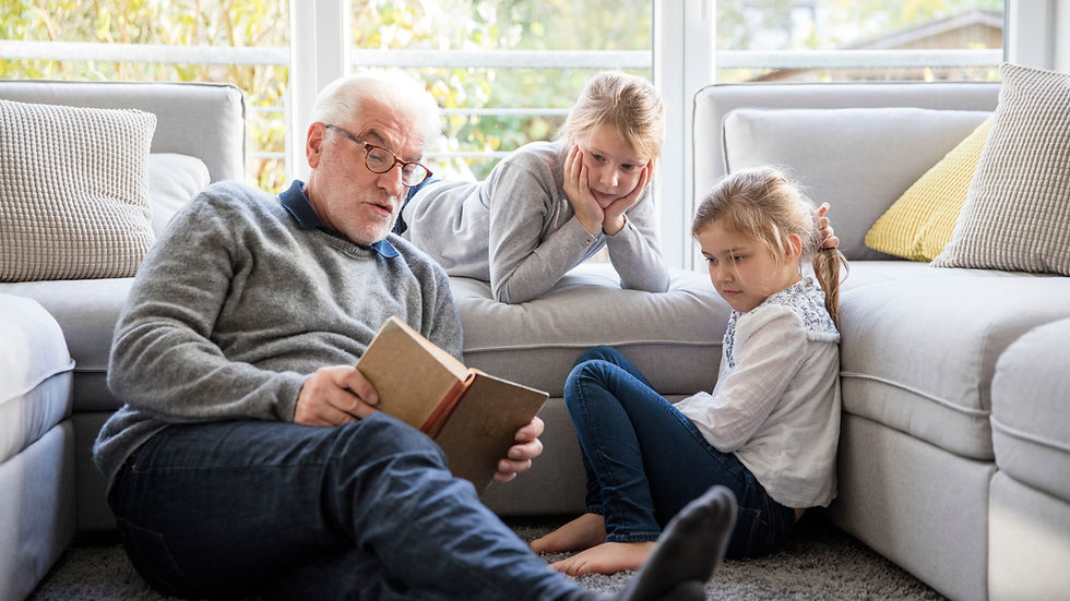 A grandfather reading a story to kids