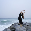 Frau am felsigen Strand
