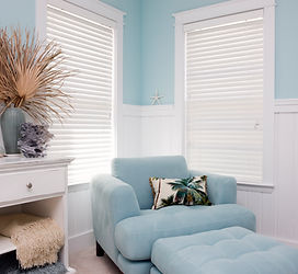 Sofa beside modern venetian blinds in a bedroom.