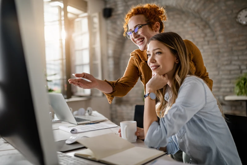 Professionals in an office viewing a monitor together