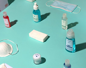 Image of Sanitizing Products such as hand sanitizers, masks on aqua colored background