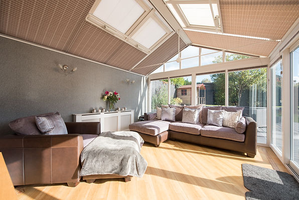 Skylights in a triangular roof with woven blinds create a bright, airy atmosphere
