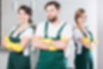 Three young people in cleaning uniforms standing together