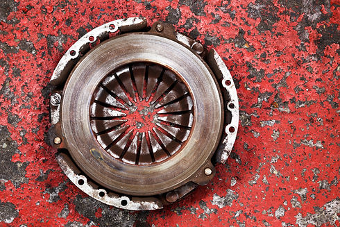 An old worn out vehicle clutch on a red background