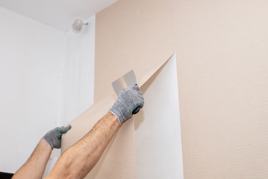 man lining up a roll of wallpaper to a wall