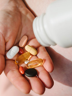 Hand holding various pills