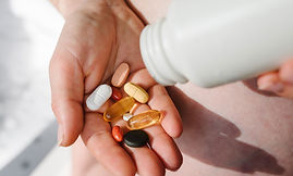 Hand holding various pills