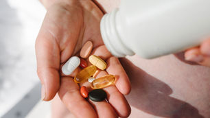 person pouring medications and vitamins into their palm