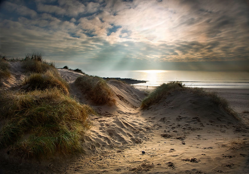 Beach in Portishead sand dunes and sun rays sky in Porthcawl, S.Wales