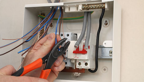 Electrician connecting wires into fuse box