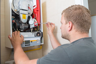 Technician repairing a gas boiler for a client