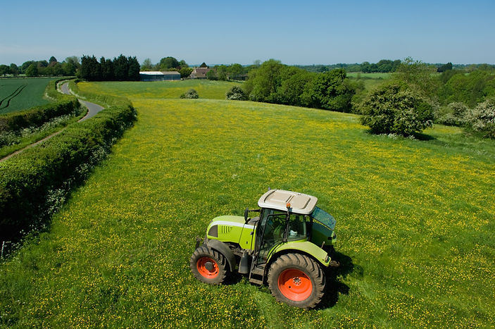 Tractor working in green fields