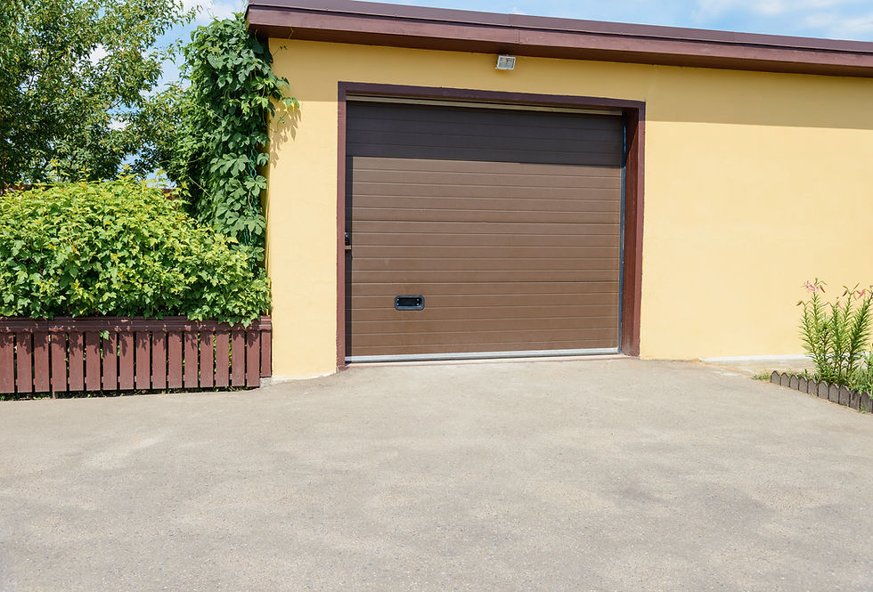 Exterior view of a building highlighting a large dark brown newly spray painted roller shutter garage door